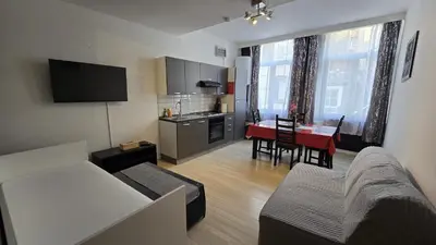 a living room with a couch and a kitchen with a table at Royal sleeping Brussels in Brussels