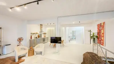 a living room with white walls and a television at Spacious loft near City Centre, Luce CasaMia in Antwerp