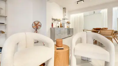 two white chairs in a living room with a table at Spacious loft near City Centre, Luce CasaMia in Antwerp