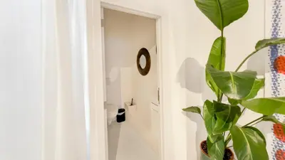 a bathroom with a plant next to a door at Spacious loft near City Centre, Luce CasaMia in Antwerp