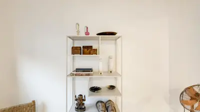 a white shelf against a white wall with items on it at Spacious loft near City Centre, Luce CasaMia in Antwerp