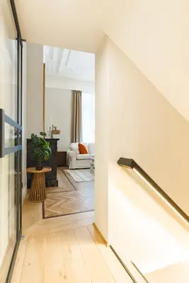 a living room with a staircase leading into a living room at Elégance du Quartier Européen Parking gratuit in Brussels