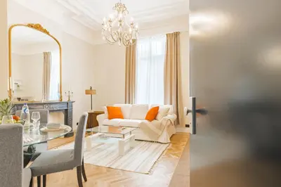 a living room with a couch and a table at Elégance du Quartier Européen Parking gratuit in Brussels
