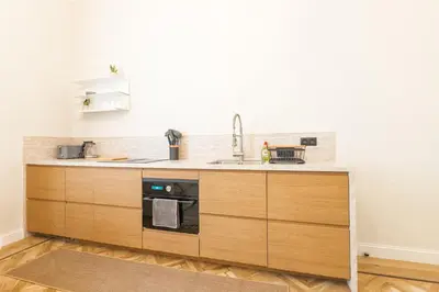 a kitchen with a sink and a stove at Elégance du Quartier Européen Parking gratuit in Brussels