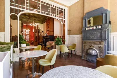 a restaurant with tables and chairs and a fireplace at Boutique Baron Osy Suite First Terrace in Antwerp