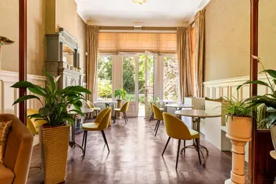 a restaurant with tables and chairs and plants at Boutique Baron Osy Suite First Terrace in Antwerp
