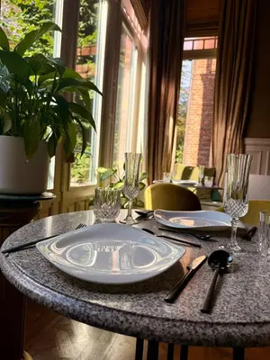 a table with plates and glasses on top of it at Boutique Baron Osy Suite First Terrace in Antwerp