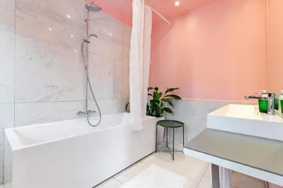 a bathroom with a shower and a tub and a sink at Boutique Baron Osy Suite First Terrace in Antwerp