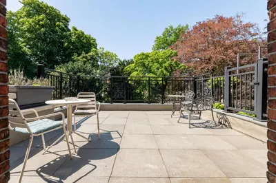 a patio with chairs and tables and a fence at Boutique Baron Osy Suite First Terrace in Antwerp