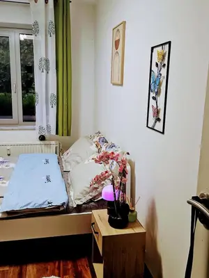 a small bedroom with a bed and a table at Chambre meublée chez l'habitant a uccle in Brussels