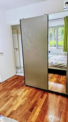 an open door in a room with a wooden floor at Chambre meublée chez l'habitant a uccle in Brussels