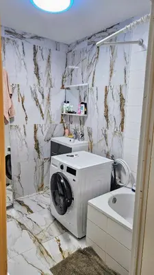 a bathroom with a washing machine and a sink at Chambre meublée chez l'habitant a uccle in Brussels