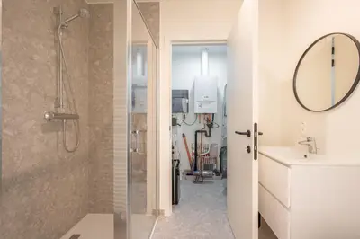 a bathroom with a shower and a sink and a mirror at Cosy Studio with Spectacular View from the Rooftop in Ghent