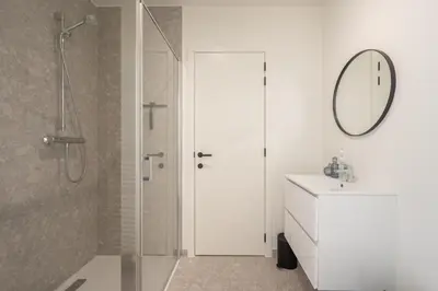 a bathroom with a shower and a sink and a mirror at Cosy Studio with Spectacular View from the Rooftop in Ghent