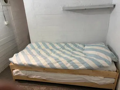 a small bed in a corner of a room at TerraVenturia - Natura Pirsch in Rixensart