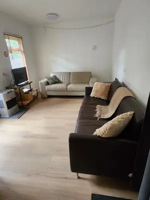 a living room with a couch and a tv at Chalet Balen in Balen