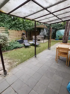 a pergola with a table and chairs on a patio at Chalet Balen in Balen