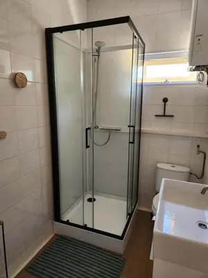 a shower with a glass door in a bathroom at Chalet Balen in Balen