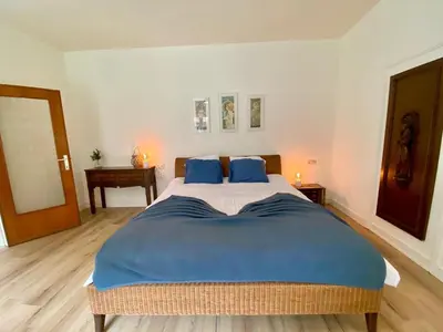 a bedroom with a large bed with blue pillows at Romantic BNB, Castle-Nature Walks, Sauna, Garden in Schilde