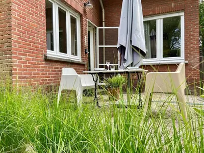 two chairs and a table with an umbrella in front of a building at Romantic BNB, Castle-Nature Walks, Sauna, Garden in Schilde
