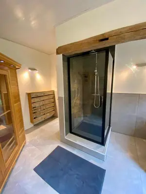 a bathroom with a glass shower with a blue rug at Romantic BNB, Castle-Nature Walks, Sauna, Garden in Schilde