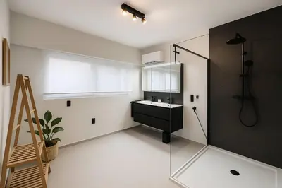 a bathroom with a sink and a glass shower at Modern Comfort - Bus & Tram at Door in Antwerp