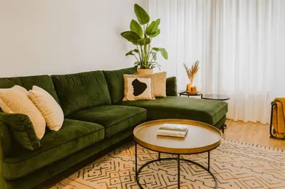 a green couch in a living room with a table at Modern Comfort - Bus & Tram at Door in Antwerp