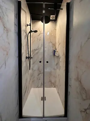 a bathroom with a shower with a glass door at Cozy Family Apartment - Bus & Tram Right in Front in Antwerp