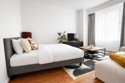 a bedroom with a bed and a living room at Cozy & Relaxing Apartment - Bus & Tram at Door in Antwerp