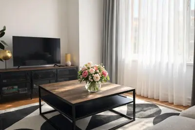 a living room with a vase of flowers on a coffee table at Cozy & Relaxing Apartment - Bus & Tram at Door in Antwerp