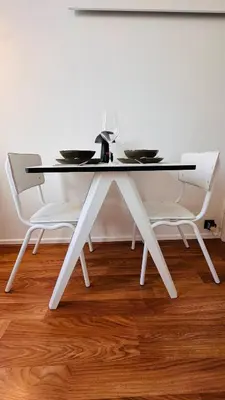 a white dining table with two white chairs at Cozy & Relaxing Apartment - Bus & Tram at Door in Antwerp