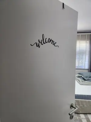 a door to a bedroom with the word welcome written on it at Mila's Cosy Place in Boortmeerbeek