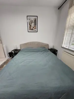 a bedroom with a bed with a blue blanket at Mila's Cosy Place in Boortmeerbeek