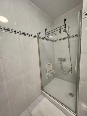 a shower with a glass door in a bathroom at Mila's Cosy Place in Boortmeerbeek