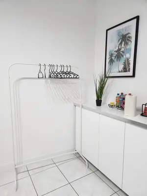 a white kitchen with white cabinets and a shelf at Mila's Cosy Place in Boortmeerbeek