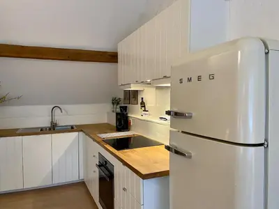 a kitchen with a white refrigerator and white cabinets at Romantic Loft, historic farmhouse, Sauna, Nature walks in Schilde