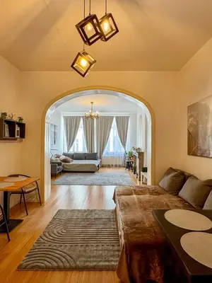 a living room with a couch and an archway at The Louise Residence in Brussels
