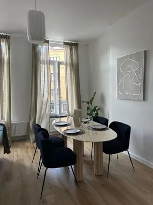 a dining room with a table and chairs at 1- Nid lumineux 2 chambres au coeur d'Ixelles in Brussels