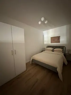 a bedroom with a bed and a white cabinet at 1- Nid lumineux 2 chambres au coeur d'Ixelles in Brussels