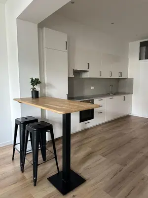 a kitchen with a wooden table and two stools at 1- Nid lumineux 2 chambres au coeur d'Ixelles in Brussels