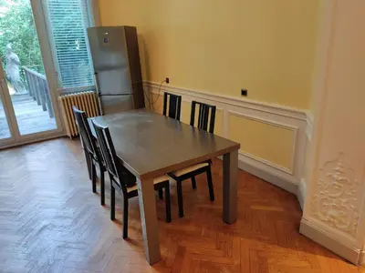 a dining room table with chairs and a refrigerator at Bright 1BR with terrace near Montgomery in Brussels