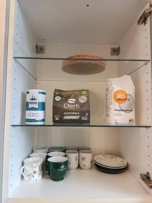 a shelf in a pantry filled with cups and plates at Bright 1BR with terrace near Montgomery in Brussels
