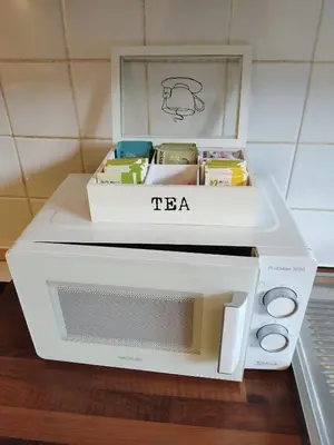 a white microwave oven sitting on top of a table at Bright 1BR with terrace near Montgomery in Brussels