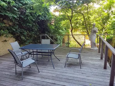 a table and chairs on a wooden deck with a statue at Bright 1BR with terrace near Montgomery in Brussels