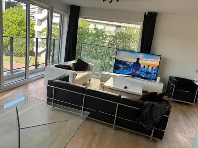 a living room with a couch and a flat screen tv at Modern City Apartment Close to Everything in Brussels