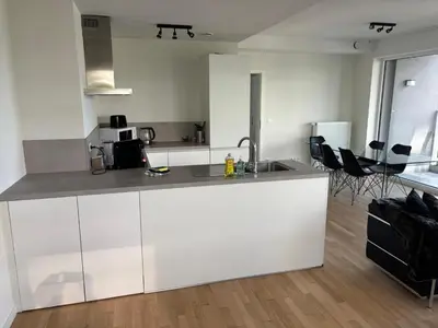 a kitchen with white cabinets and a counter top at Modern City Apartment Close to Everything in Brussels