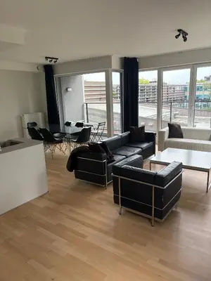 a living room with black couches and a table at Modern City Apartment Close to Everything in Brussels