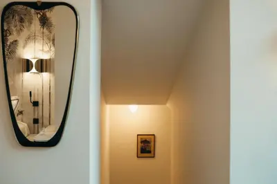 a mirror hangs on the wall in a hallway at La Villa Maurice in Brussels