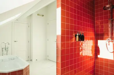 a bathroom with red tiles on the wall and a sink at La Villa Maurice in Brussels