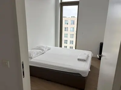 a white bed in a room with a window at Top floor luxury with spectacular water views in Brussels